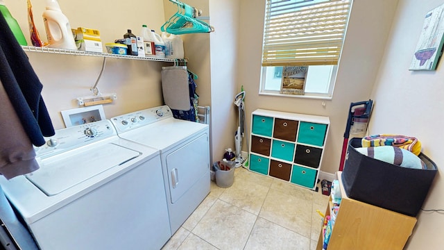 laundry area with light tile patterned flooring and washer and dryer