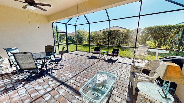 view of patio with glass enclosure and ceiling fan