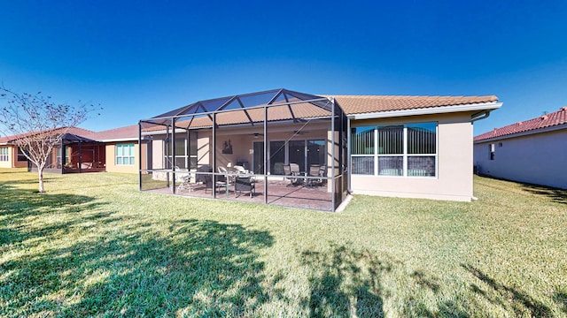 back of property featuring a patio area, a lanai, and a lawn