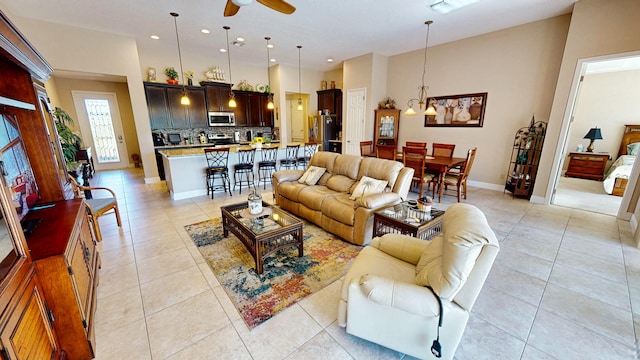 tiled living room featuring ceiling fan with notable chandelier