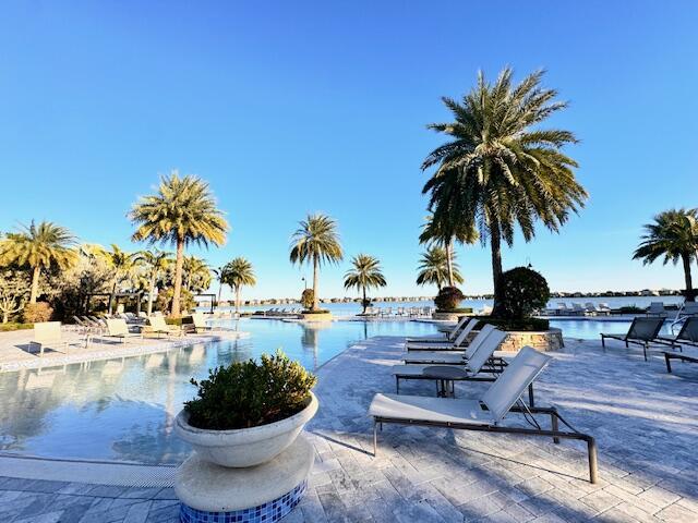 view of pool featuring a water view and a patio area