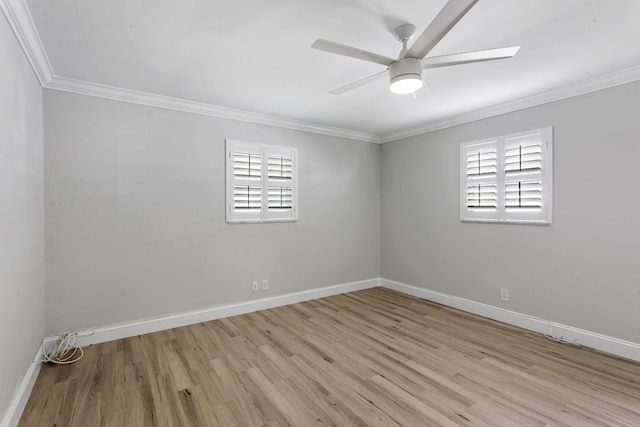 empty room featuring a healthy amount of sunlight, ornamental molding, and light hardwood / wood-style flooring