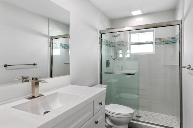 bathroom featuring vanity, toilet, and walk in shower