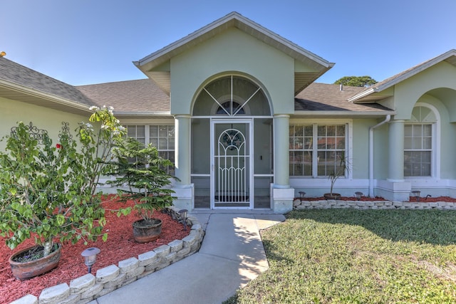 entrance to property featuring a lawn