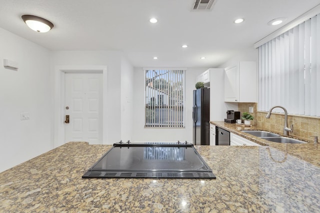 kitchen with sink, tasteful backsplash, stone countertops, white cabinets, and black appliances