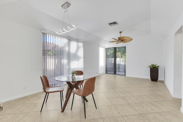 tiled dining room with ceiling fan with notable chandelier and lofted ceiling