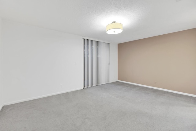 unfurnished room featuring carpet flooring and a textured ceiling