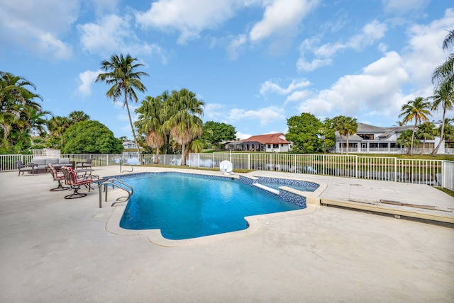 view of swimming pool featuring a patio area and an in ground hot tub