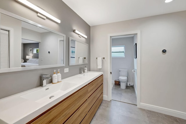 bathroom with tile patterned flooring, vanity, and toilet