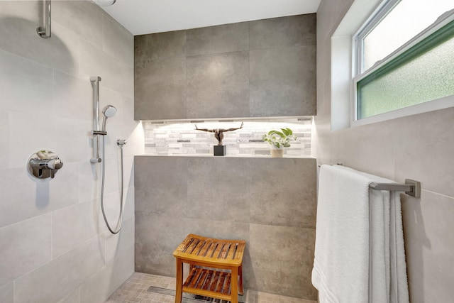 bathroom with tile patterned floors, tiled shower, and tile walls