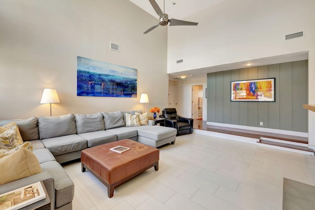 tiled living room featuring ceiling fan and high vaulted ceiling