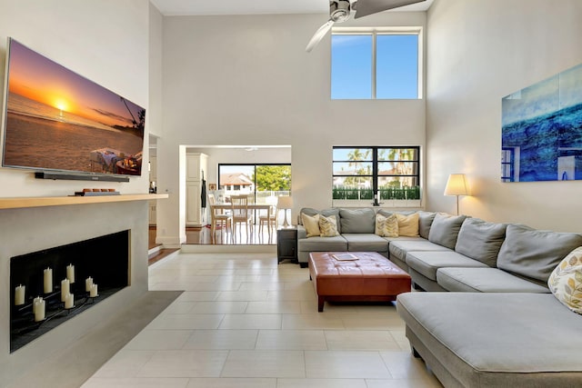 living room with ceiling fan and a towering ceiling