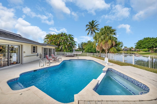 view of pool featuring a patio area, an in ground hot tub, and a water view