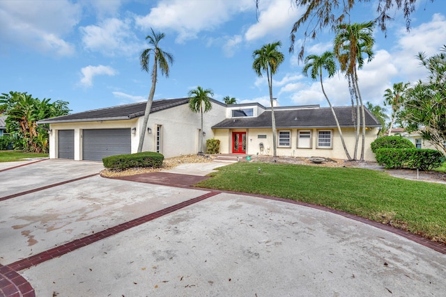 view of front of home with a garage and a front lawn