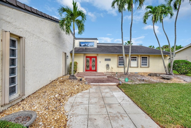 single story home featuring a front yard and french doors