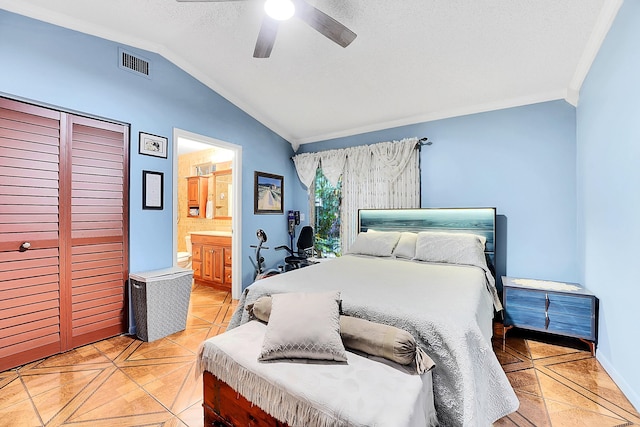 tiled bedroom featuring vaulted ceiling, ensuite bathroom, ornamental molding, ceiling fan, and a textured ceiling