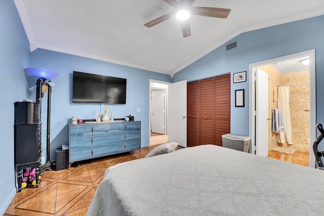 tiled bedroom featuring lofted ceiling, ensuite bath, ceiling fan, ornamental molding, and a closet