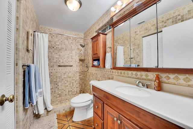 bathroom with tile walls, a shower with shower curtain, vanity, tile patterned floors, and toilet