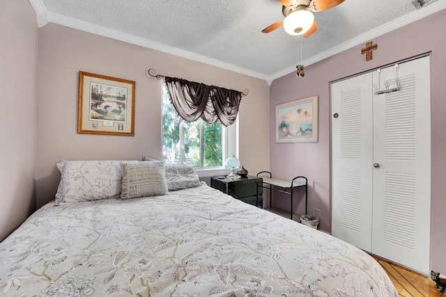 bedroom featuring crown molding, ceiling fan, wood-type flooring, a textured ceiling, and a closet