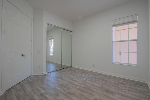 unfurnished bedroom featuring wood finished floors and baseboards