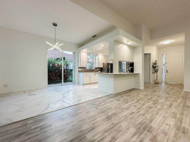 kitchen featuring white cabinets, visible vents, open floor plan, and stainless steel fridge with ice dispenser