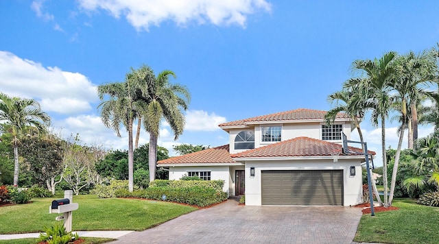 mediterranean / spanish house with a front lawn and a garage