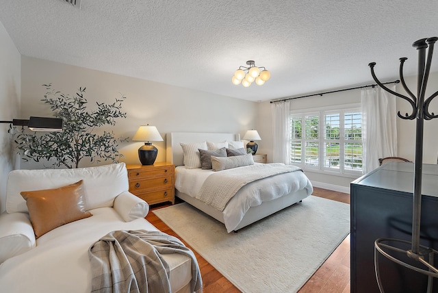 bedroom featuring hardwood / wood-style flooring and a textured ceiling