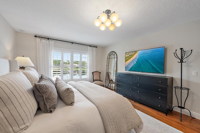 bedroom with hardwood / wood-style floors and a textured ceiling