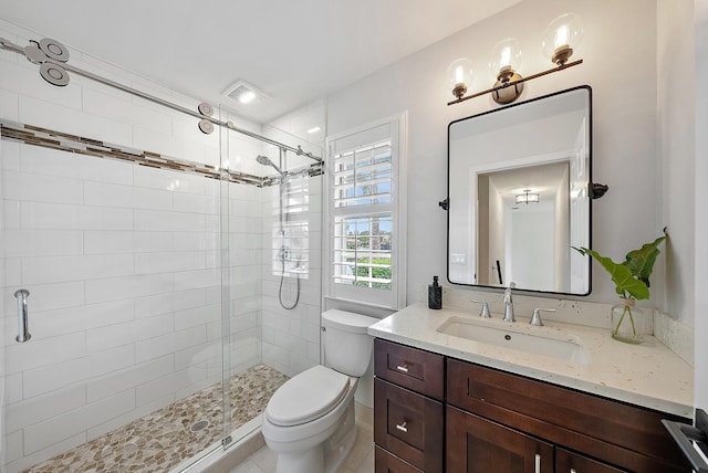 bathroom featuring vanity, an enclosed shower, and toilet