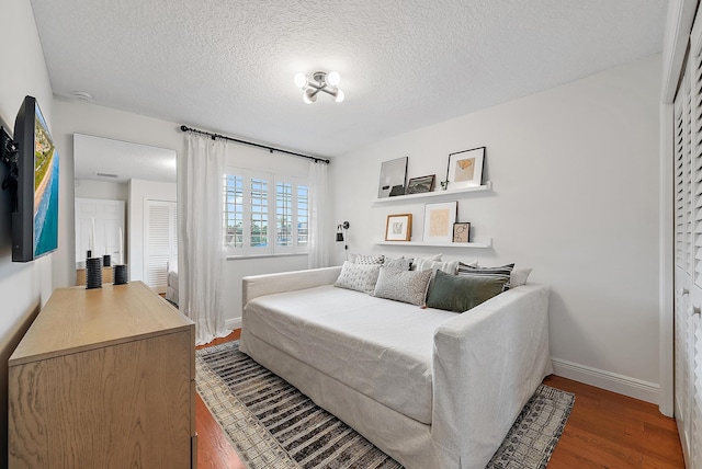 bedroom featuring a textured ceiling and dark hardwood / wood-style flooring