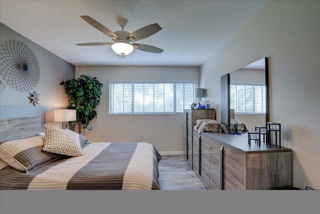 bedroom with light hardwood / wood-style floors, multiple windows, and ceiling fan