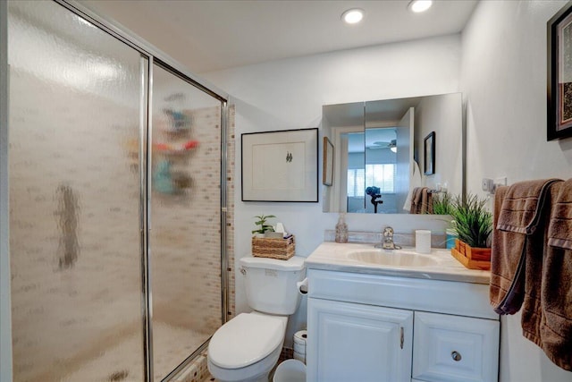 bathroom with vanity, toilet, and a shower with shower door