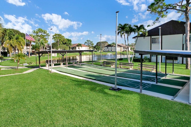 surrounding community featuring a water view and a lawn