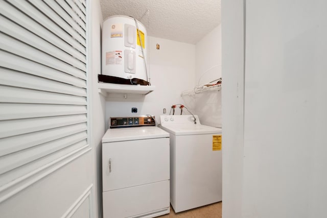 laundry area with washer and dryer, a textured ceiling, and electric water heater