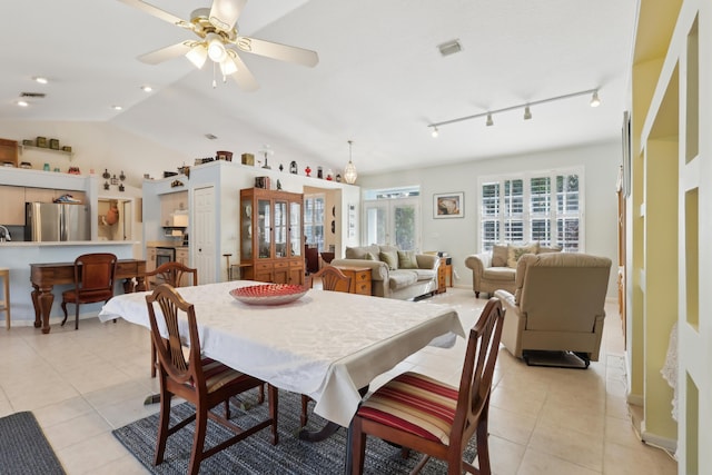 dining room featuring ceiling fan, rail lighting, light tile patterned floors, and vaulted ceiling