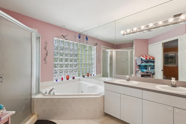 bathroom featuring a textured ceiling, vanity, and plus walk in shower