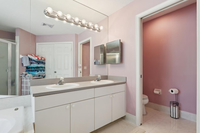 bathroom with toilet, vanity, tile patterned floors, and walk in shower