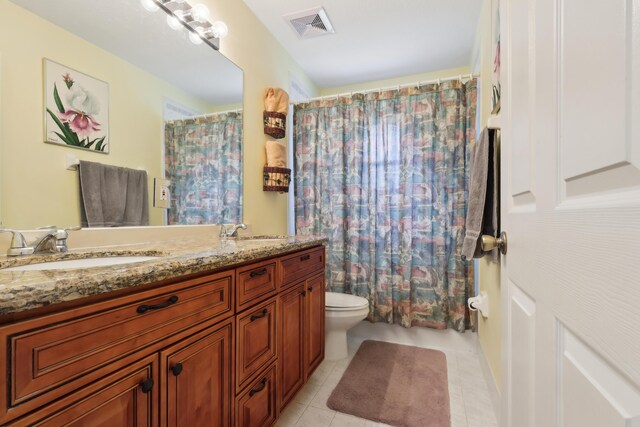 bathroom featuring toilet, tile patterned flooring, vanity, and curtained shower