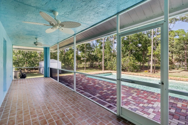 unfurnished sunroom with ceiling fan