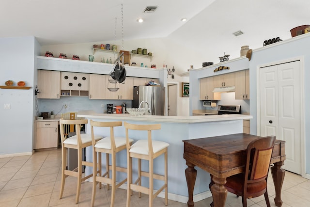 kitchen featuring lofted ceiling, extractor fan, light tile patterned flooring, appliances with stainless steel finishes, and light brown cabinets