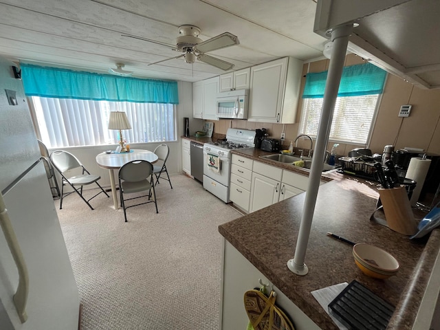 kitchen featuring white cabinets, white appliances, plenty of natural light, and ceiling fan