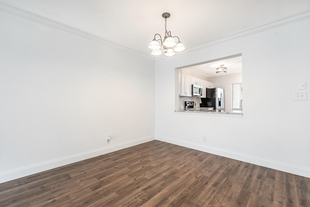 spare room featuring crown molding, sink, dark hardwood / wood-style floors, and an inviting chandelier