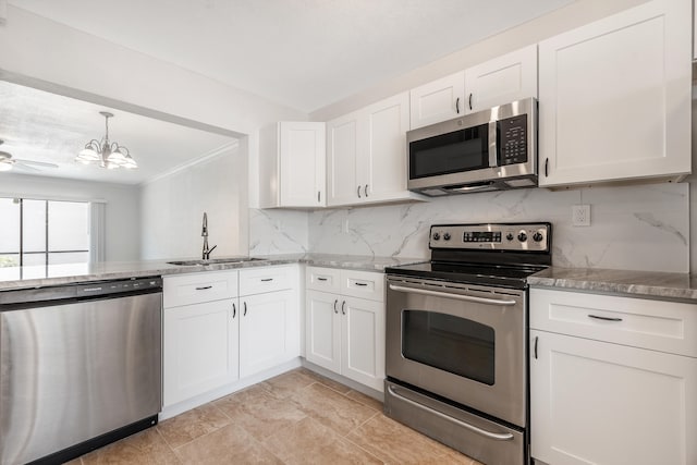 kitchen with sink, stainless steel appliances, backsplash, white cabinets, and ceiling fan with notable chandelier