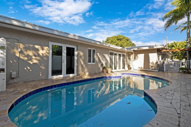 outdoor pool with a patio and french doors