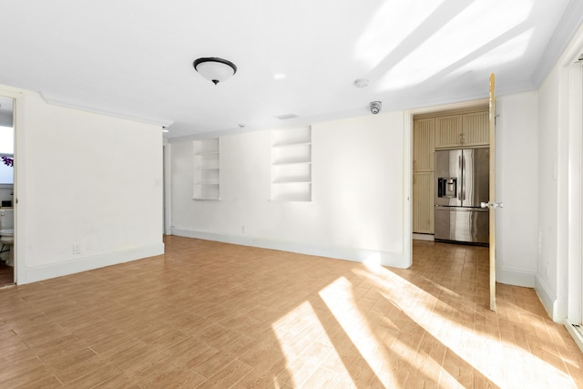 unfurnished living room with crown molding, built in features, and light wood-type flooring