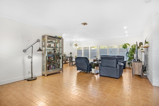 living area featuring baseboards, brick wall, light wood-type flooring, and an inviting chandelier