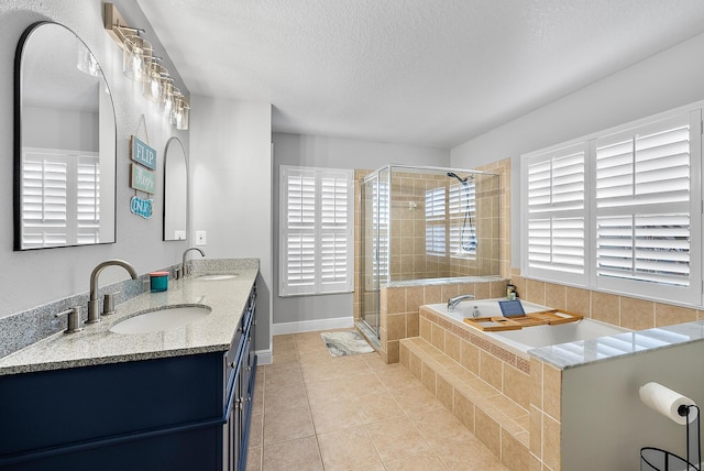 bathroom featuring tile patterned flooring, vanity, a shower with door, and a textured ceiling