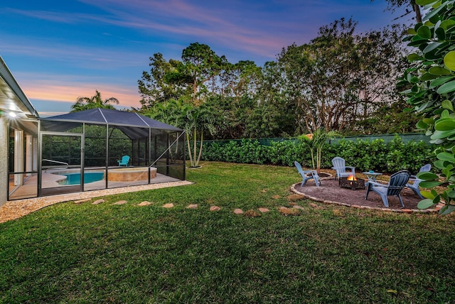 yard at dusk featuring a fenced in pool, a lanai, a patio area, and a fire pit