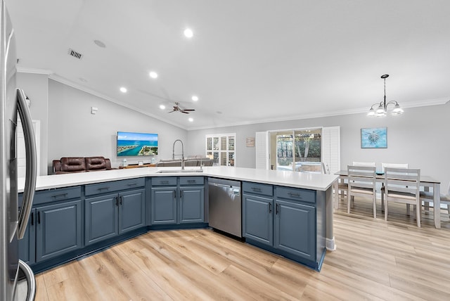 kitchen with sink, stainless steel appliances, light hardwood / wood-style floors, decorative light fixtures, and vaulted ceiling