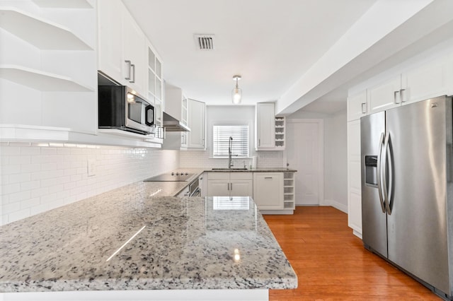 kitchen featuring black appliances, sink, light wood-type flooring, light stone counters, and white cabinetry